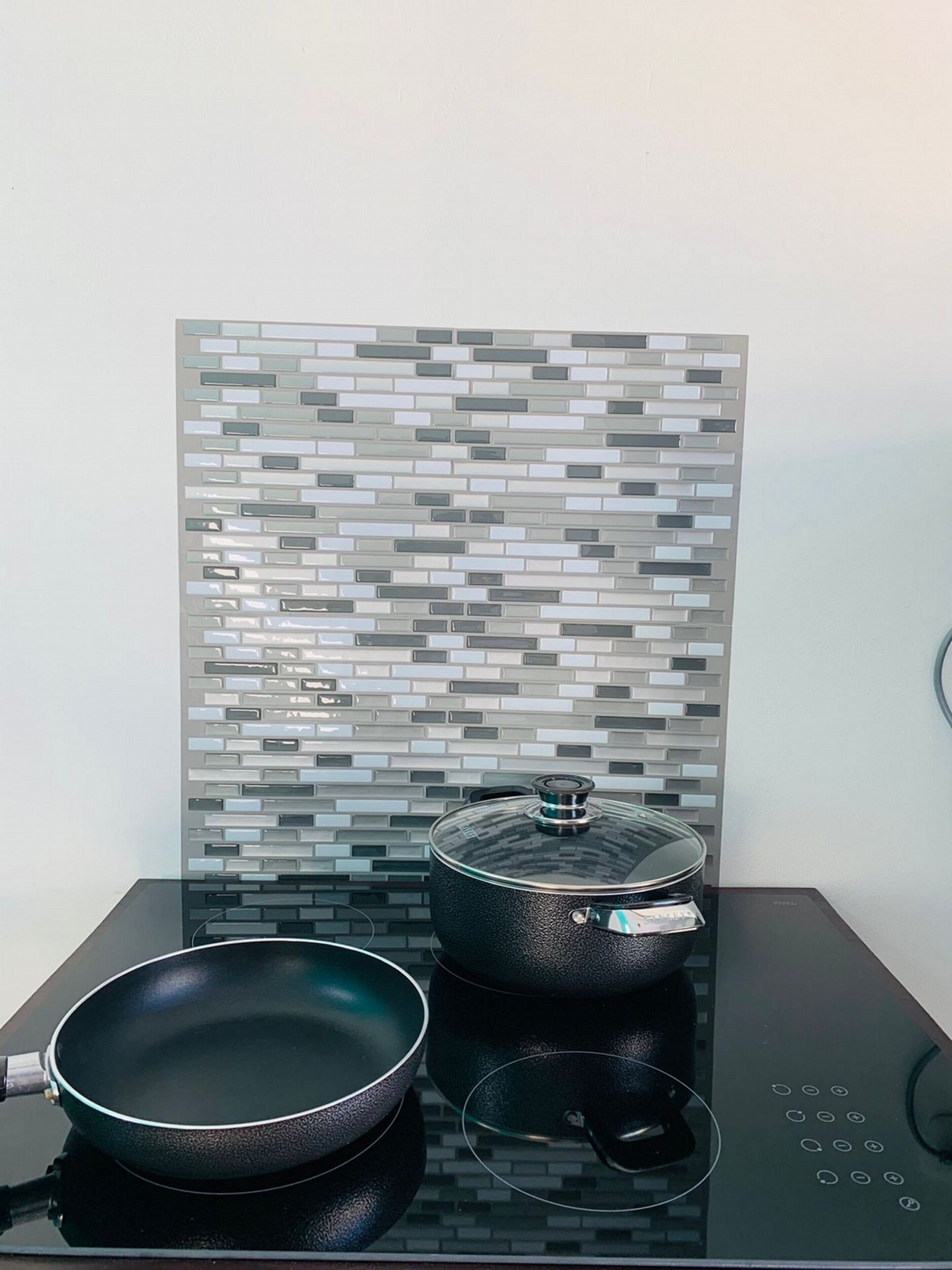 Una cocina con encimera negra, una sartén y una olla con tapa.