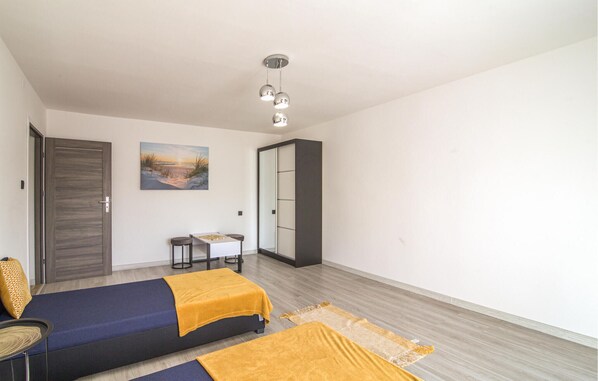 A room with two beds, a small table, and a chair.