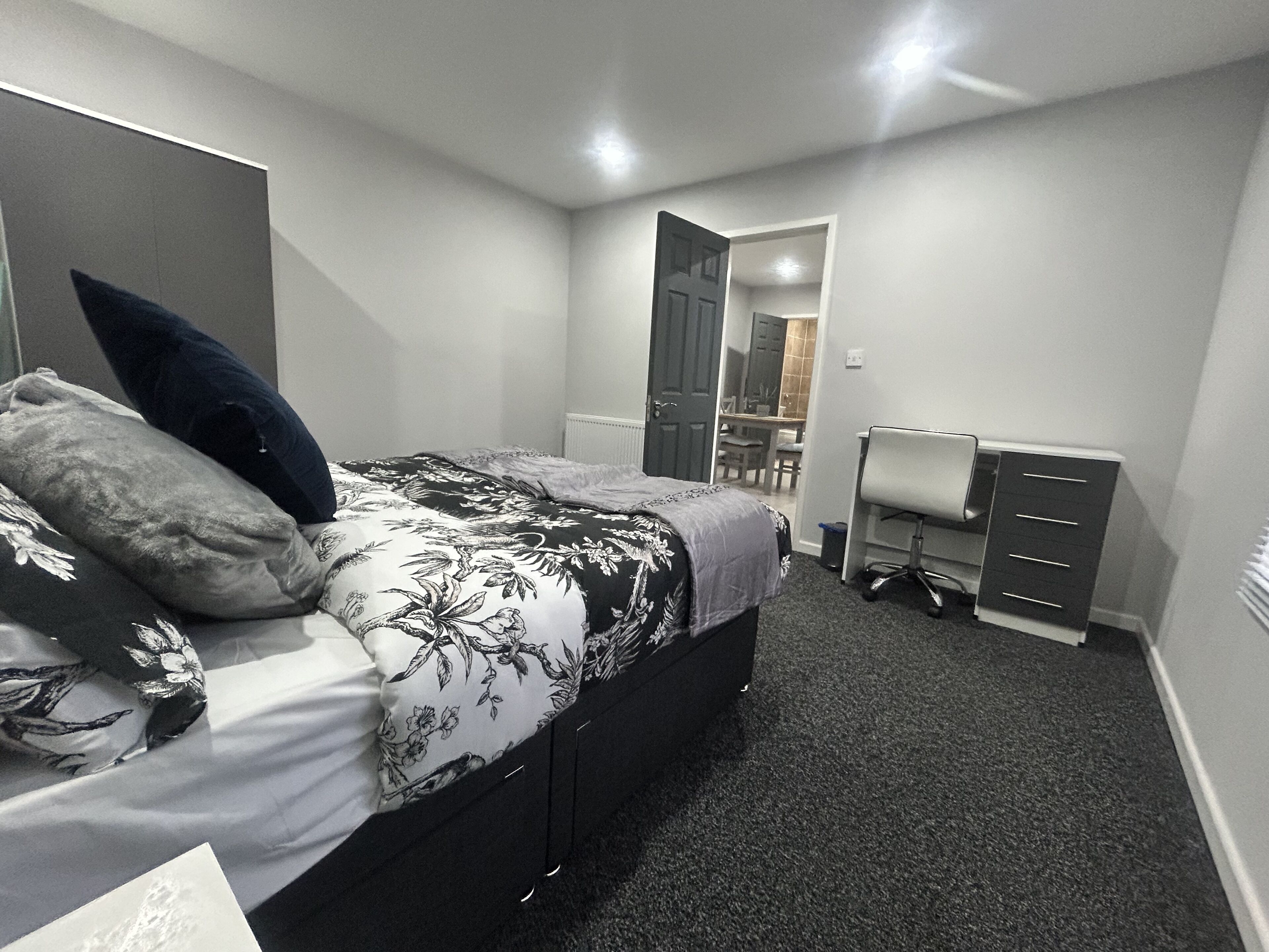 Une chambre à coucher avec un lit, un bureau et une chaise.