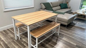 Un salon moderne avec une table et un banc en bois, un canapé et une lampe.