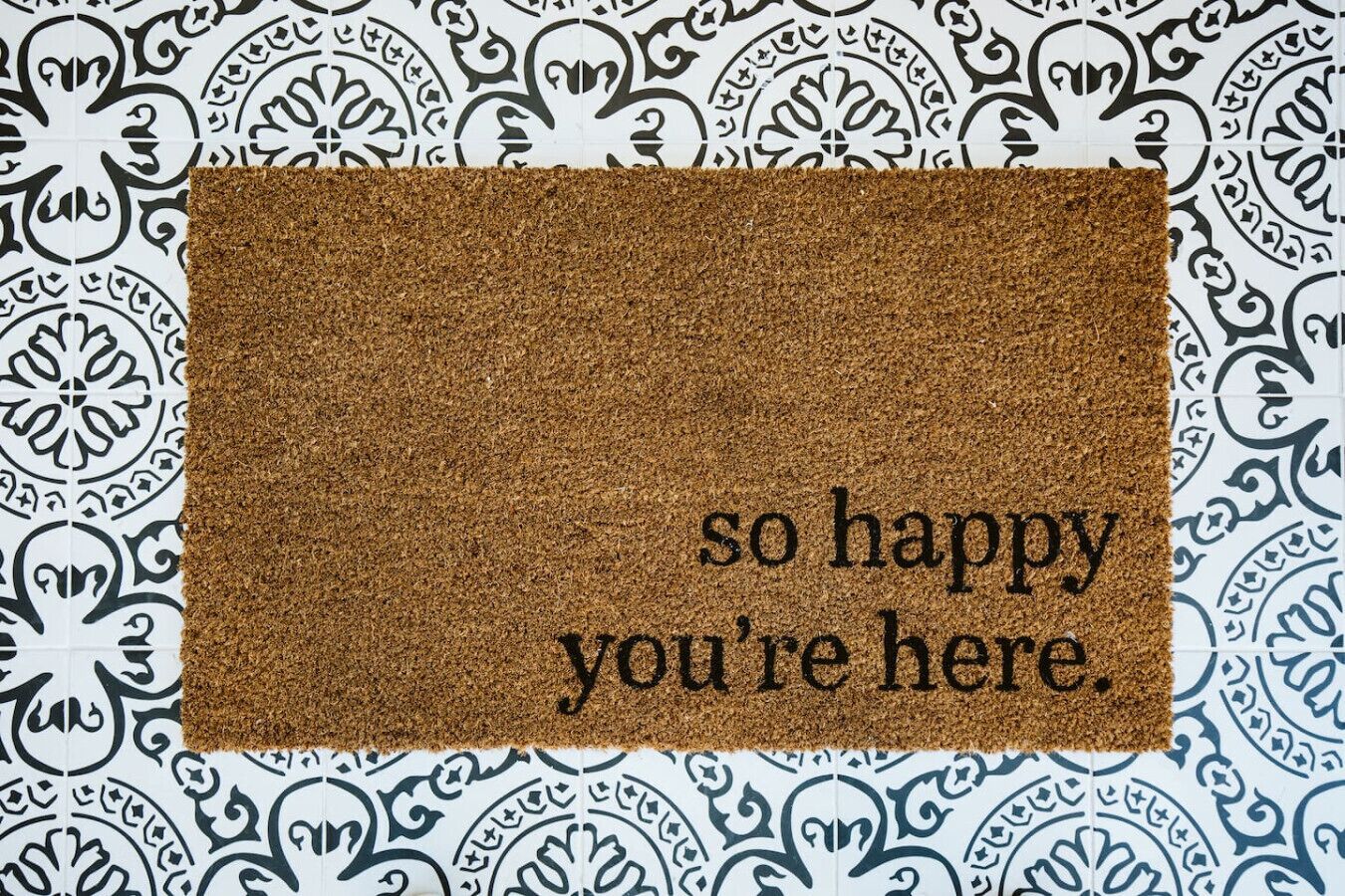 A doormat with the text "so happy you're here."