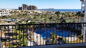 A resort with a pool, palm trees, and a view of the ocean. - Casa Blanca D 405 · Sandy Beach 2 BR Condo (Puerto Peñasco)