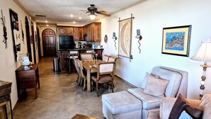 Tilava olohuone, jossa on sohva ja ruokailutila, ja jossa on käytetty puuhuonekaluja.