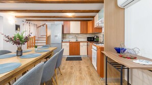 Una cocina compacta con armarios de madera, horno integrado y microondas.