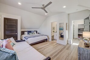 A bedroom with a bed, a desk, a chair, a ceiling fan, and a bathroom visible through an open door. - Brand New | 3 Beds | Mini Golf | Lazy River | RR (Washington)