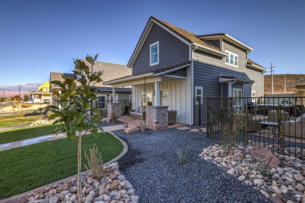 A modern two-story house with a stone patio, a fenced backyard, and a clear view of the surrounding neighborhood. - Brand New | 3 Beds | Mini Golf | Lazy River | RR (Washington)