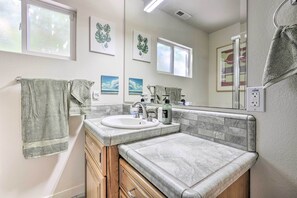 A bathroom with a sink, mirror, and towel rack. There are framed pictures on the wall and a window above the sink. - Peaceful Petaluma Getaway w/ Deck + Grill! (Petaluma)