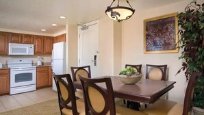 A dining area with a wooden table and chairs, a bowl of plants, and a painting on the wall. - Resort near airport, convention center & casinos. (Las Vegas)