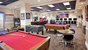 A recreational area with pool tables, foosball tables, and a foosball table with a red tablecloth. - Resort near airport, convention center & casinos. (Las Vegas)
