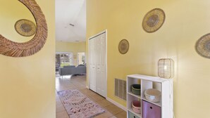 A hallway with a patterned rug, a white door, and a white console with shelves. - Private Pool, Gated Golf Community (Kissimmee)