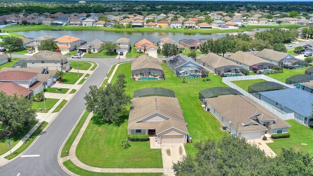 A residential area with houses, a road, and a lake. - Private Pool, Gated Golf Community (Kissimmee)