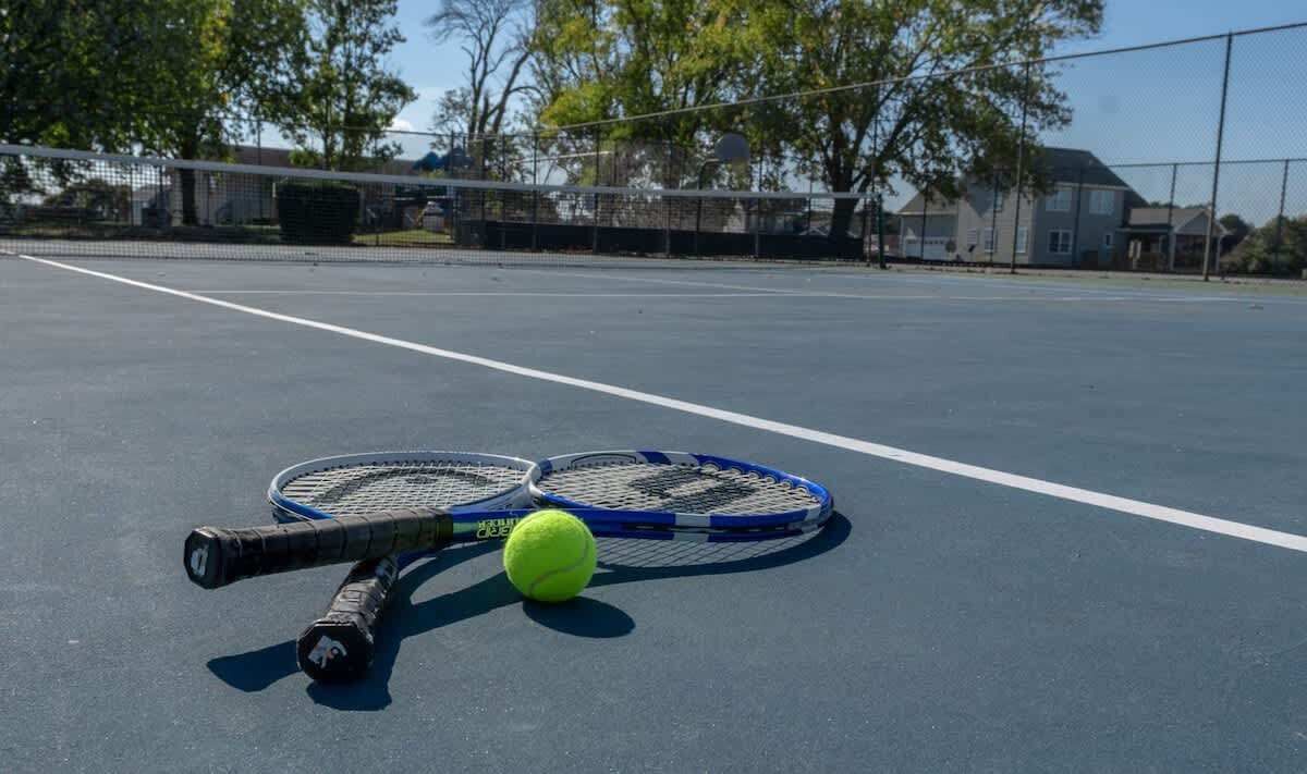 Ein Tennisplatz mit zwei Schlägern und einem Tennisball.
