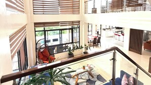A multi-level hotel interior with a central atrium, a staircase, and a dining area. - Picturesque private villa with infinity pool (Puerto Galera)