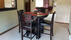 A dining area with a round table, chairs, and a mirror on the wall. - Winding River - Panoramic view of river valley, under 10 minutes to Dreams Park (Cooperstown)