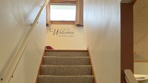 A carpeted staircase with a 'Welcome Sit, Relax & Enjoy' sign above it. - Winding River - Panoramic view of river valley, under 10 minutes to Dreams Park (Cooperstown)