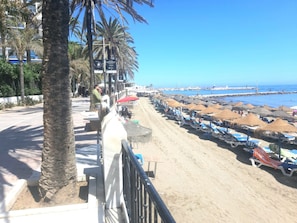 Rannalla, aurinkotuoleja, rantapyyhkeitä