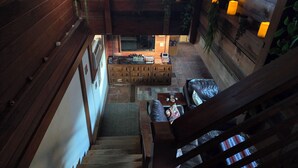 A cozy, rustic interior with wooden walls, a central seating area, and multiple lit candles on shelves. - Scenic Getaway - Rustic Cabin - Mountain Ridge (Pinon Hills)