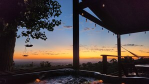 A hot tub area with a view of the sunset and cityscape. - Scenic Getaway - Rustic Cabin - Mountain Ridge (Pinon Hills)