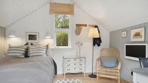 A cozy bedroom with a bed, dresser, chair, and a TV. - Beautiful home in Vig with WiFi (Vig)