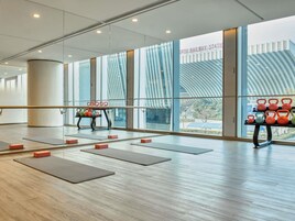 A spacious gym with exercise mats, kettlebells, and a ballet barre.