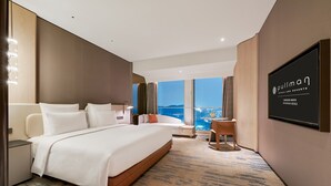 A hotel room with a large bed, a desk, a chair, and a TV on the wall. - Pullman Shenzhen North (Shenzhen)