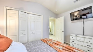 A bedroom with a bed, a dresser, a television, and a closet. - Walk to Lake: Townhome w/ Hot Tub in Afton! (Afton)