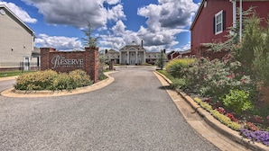 A gated entrance to a residential area with a sign reading "The Reserve" and a large house in the background. - Walk to Lake: Townhome w/ Hot Tub in Afton! (Afton)