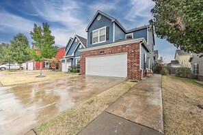 Una casa residencial con garaje, entrada para coches y césped.