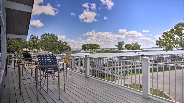 A wooden deck with outdoor seating and a view of a marina. - Walk to Lake: Townhome w/ Hot Tub in Afton! (Afton)