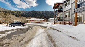 Una carretera nevada que conduce a un edificio de varios pisos, con un telesilla visible al fondo.