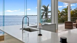 Una cocina moderna con vista al mar, un lavabo y una lámpara.