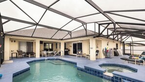 An indoor swimming pool with a glass ceiling, surrounded by lounge chairs and a bar area. - 25%off/Close to Disney/Hot Tub/Private Pool/Fenced (Davenport)