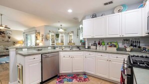 A modern kitchen with white cabinets, a dishwasher, and a gas stove. - 25%off/Close to Disney/Hot Tub/Private Pool/Fenced (Davenport)