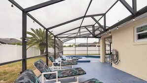 A covered outdoor area with lounge chairs and a pool. - 25%off/Close to Disney/Hot Tub/Private Pool/Fenced (Davenport)