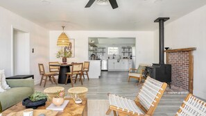 Una sala de estar moderna con comedor, cocina y chimenea.