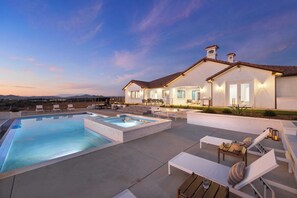 A modern house with a large swimming pool, outdoor seating, and a well-lit patio area. - Pinot Point by Avantstay Massive Estate, 10 Mins From Temecula Wineries (Temecula)