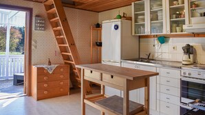 A kitchen with wooden cabinets, a built-in oven, and a wooden table. - Cozy home in Kyrkhult with WiFi (Kyrkhult)