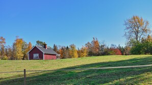 A red barn on a grassy field with trees in the background. - Cozy home in Kyrkhult with WiFi (Kyrkhult)