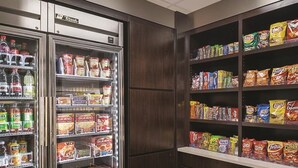 A refrigerated section with various beverages and snacks, including bottled water, soda, and boxed food items. - King Bed, Non- Smoking at La Quinta Inn & Suites by Wyndham Ontario Airport (Ontario)