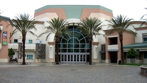A building with a large arched entrance, palm trees, and a sign for the Paul A. Gianini Library. - King Bed, Non- Smoking at La Quinta Inn & Suites by Wyndham Ontario Airport (Ontario)