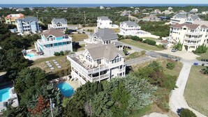 A large residential building with multiple balconies, a swimming pool, and a well-maintained lawn. - Semi-Oceanfront, Private Pool, Hot Tub, Ocean Views (Avon)
