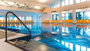 An indoor swimming pool with yellow chairs and a clear ceiling. - Cosy apartment for 4 guests with WIFI, TV, balcony and pets allowed (Vergötschen)