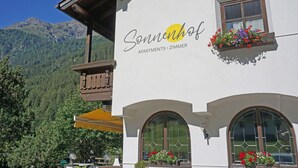 A building with a sign reading "Sonnenhof Apartments - Zimmer" and a balcony with wooden railings. - Cosy apartment for 4 guests with WIFI, TV, balcony and pets allowed (Vergötschen)
