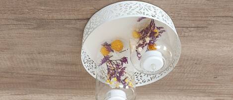 Un jarrón de vidrio transparente con flores secas sobre una superficie de madera.