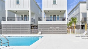 Ein modernes Gebäude mit Pool und Liegestühlen.