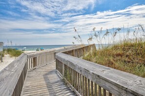 A wooden boardwalk leading to a beach with sand and sea in the background. - Coastal Haven by Sea & Lagoon (Gulf Shores)