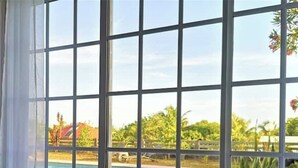 A window with a view of a swimming pool and greenery. - Villa Oneway with swimming pool - Rated 3 stars ⭐⭐⭐ (Sainte-Rose)