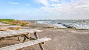 A coastal picnic area with benches and a paved path leading to the beach. - Awesome home in Heinkenszand with WiFi (Heinkenszand)