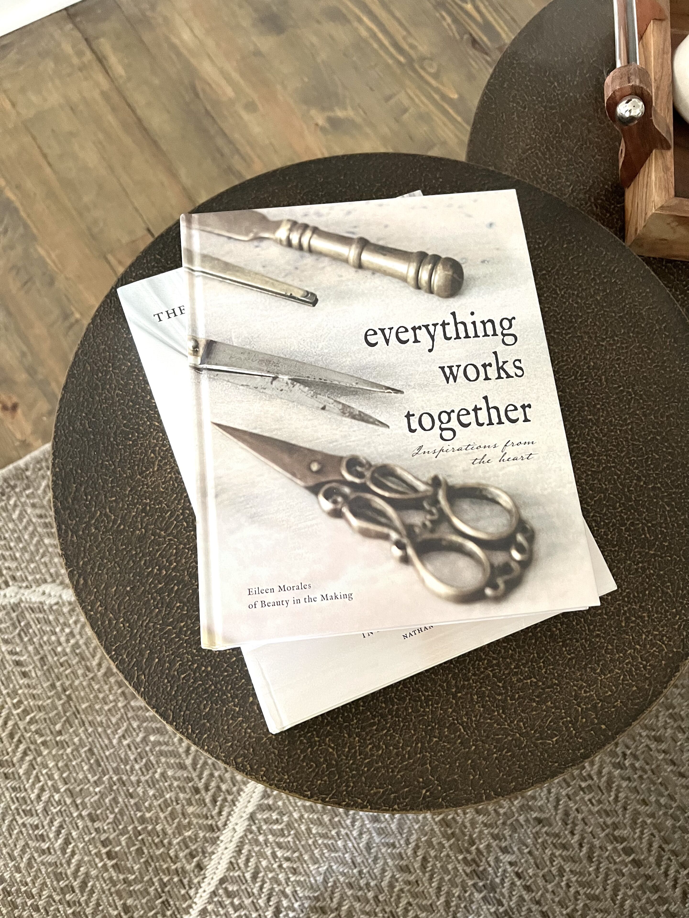 En bog med titlen 'everything works together' af Eileen Morales på et rundt bord.