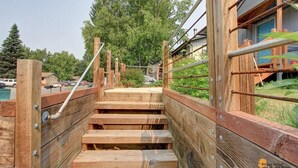 A wooden staircase leading to a building with a metal railing. - Upper Grape, Midtown Home 2bed&1bath (Anchorage)